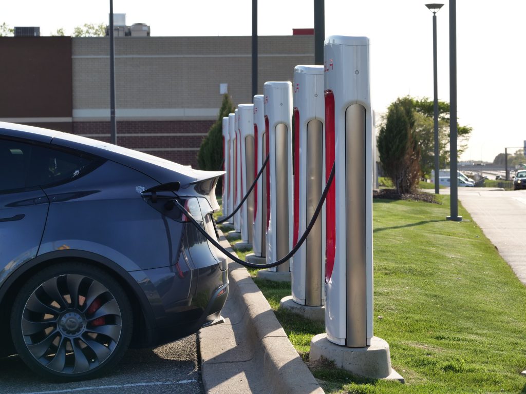 Services Electric car plugged into a row of charging stations, showcasing modern EV infrastructure.